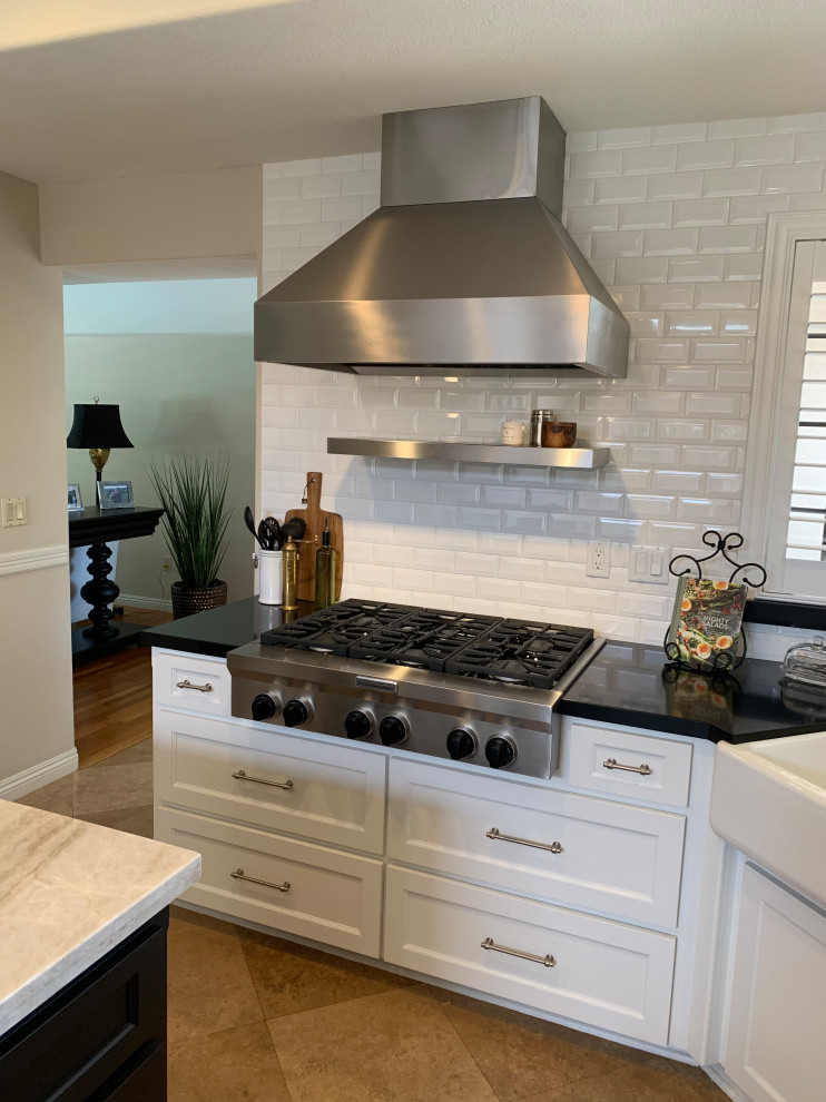 Foto på ett mellanstort vit kök, med en rustik diskho, marmorbänkskiva, vitt stänkskydd, stänkskydd i tegel, rostfria vitvaror, cementgolv, en köksö och brunt golv