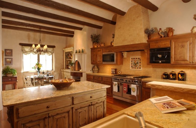 アルバカーキにある高級な広いサンタフェスタイルのおしゃれなキッチン (ヴィンテージ仕上げキャビネット、シルバーの調理設備) の写真