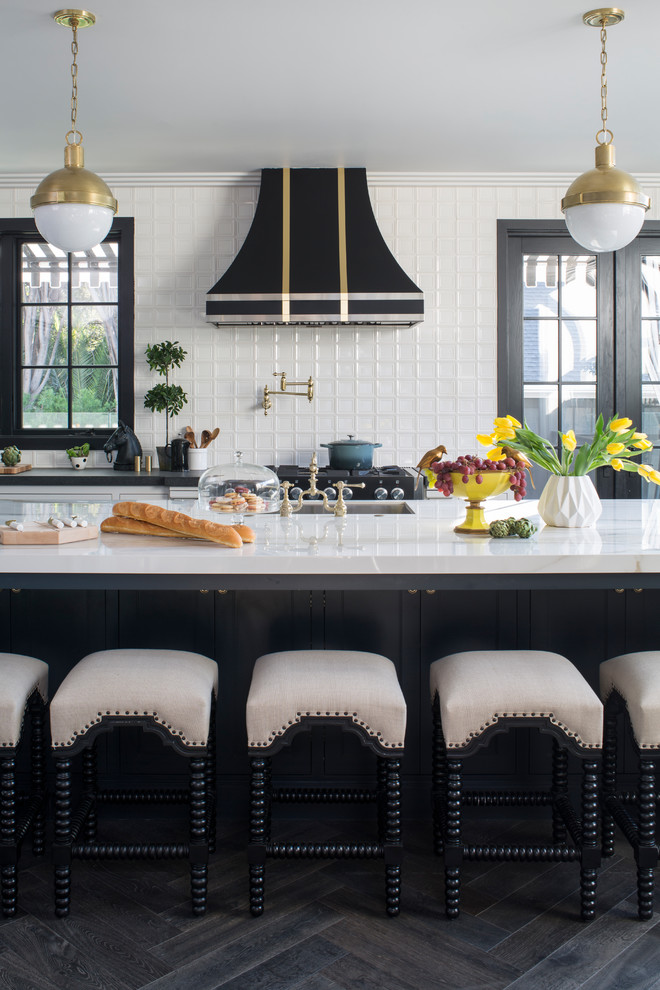 Klassisk inredning av ett mycket stort kök, med en undermonterad diskho, luckor med profilerade fronter, vita skåp, bänkskiva i kvarts, vitt stänkskydd, stänkskydd i porslinskakel, rostfria vitvaror, mellanmörkt trägolv, en köksö och brunt golv