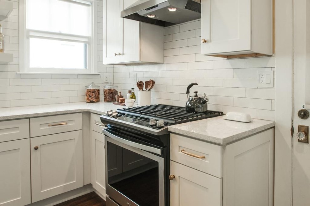 Example of a mid-sized trendy l-shaped medium tone wood floor and brown floor eat-in kitchen design in Nashville with a single-bowl sink, shaker cabinets, white cabinets, quartz countertops, white backsplash, subway tile backsplash, stainless steel appliances and an island