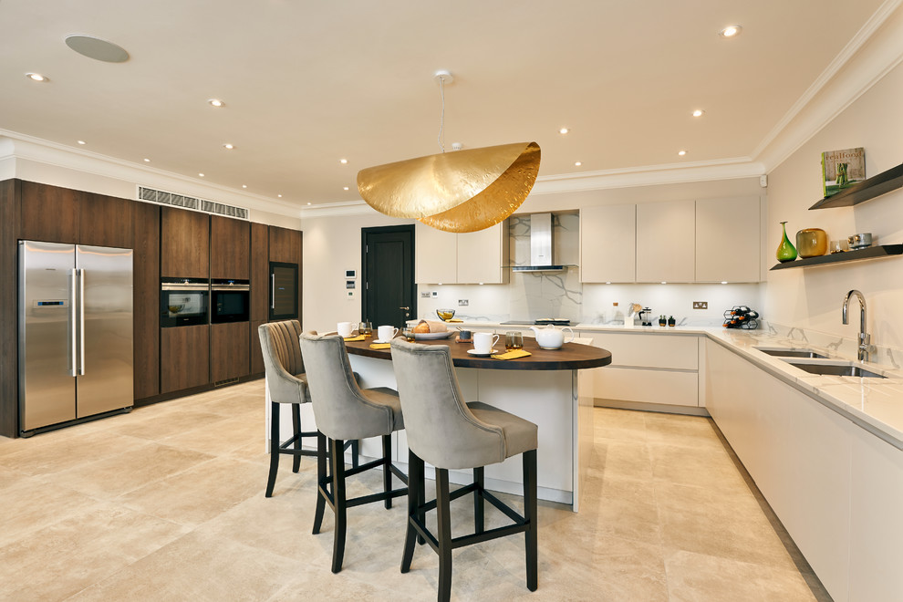 Open concept kitchen - large contemporary u-shaped porcelain tile and beige floor open concept kitchen idea in London with flat-panel cabinets, white cabinets, quartz countertops, white backsplash, stainless steel appliances, an island, white countertops and a double-bowl sink