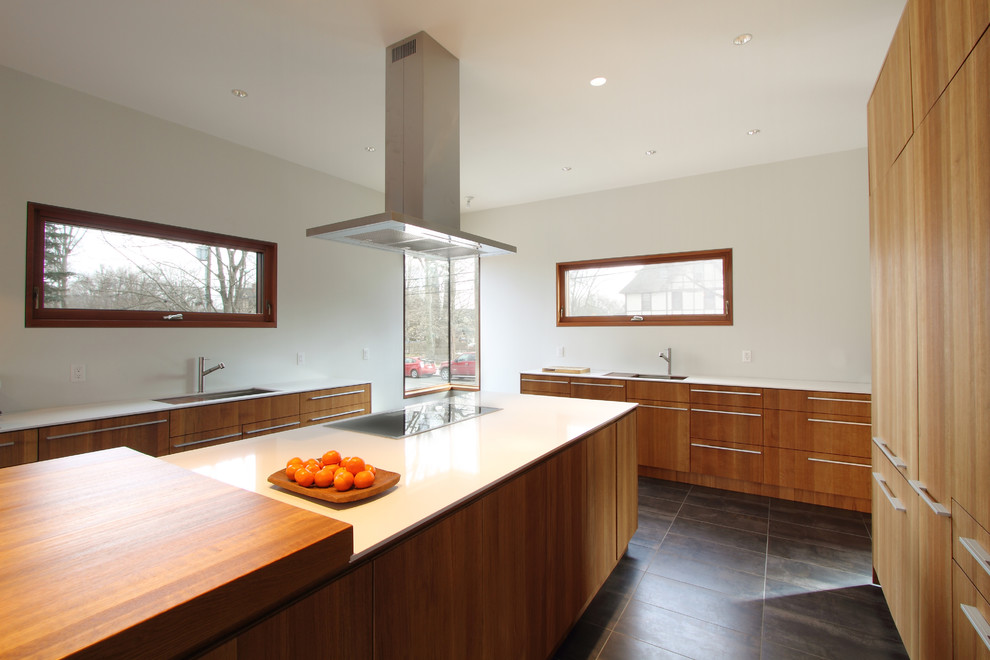 Esempio di una grande cucina design con lavello a doppia vasca, ante lisce, ante in legno chiaro, top in superficie solida, elettrodomestici in acciaio inossidabile, pavimento in gres porcellanato e pavimento marrone
