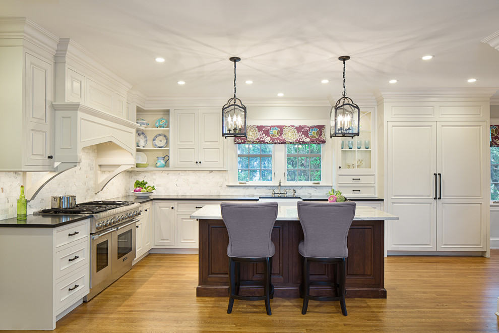 Large elegant l-shaped dark wood floor enclosed kitchen photo in New York with a farmhouse sink, beaded inset cabinets, white cabinets, granite countertops, multicolored backsplash, subway tile backsplash, paneled appliances and an island