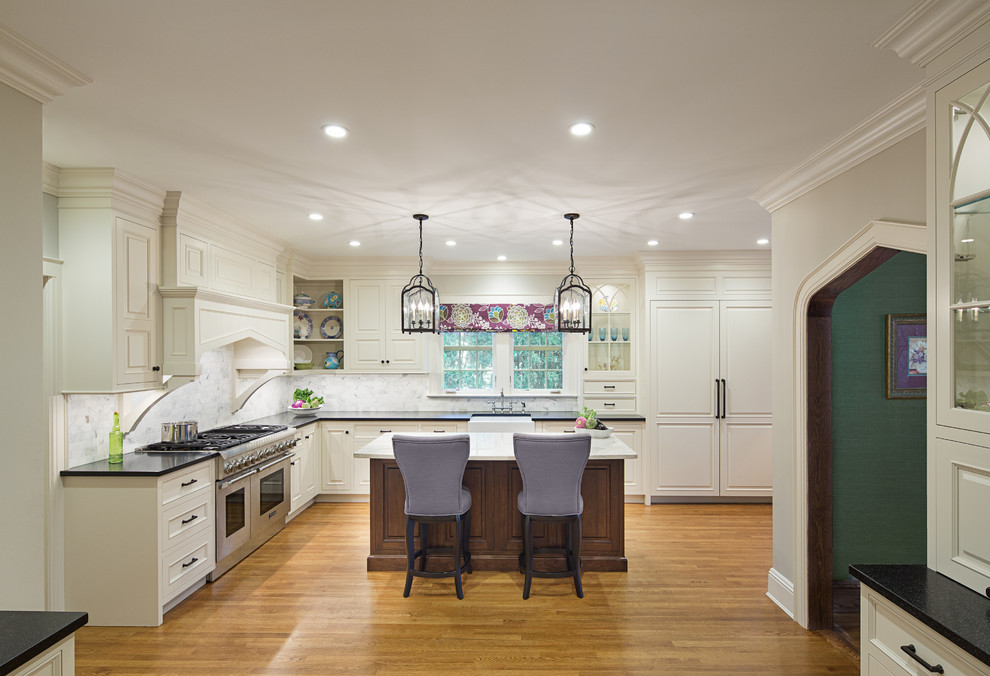 Large elegant l-shaped dark wood floor enclosed kitchen photo in New York with a farmhouse sink, beaded inset cabinets, white cabinets, granite countertops, multicolored backsplash, subway tile backsplash, paneled appliances and an island