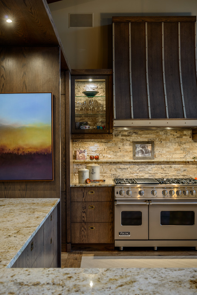 バンクーバーにあるコンテンポラリースタイルのおしゃれなキッチン (フラットパネル扉のキャビネット、濃色木目調キャビネット、ベージュキッチンパネル、石タイルのキッチンパネル、シルバーの調理設備) の写真
