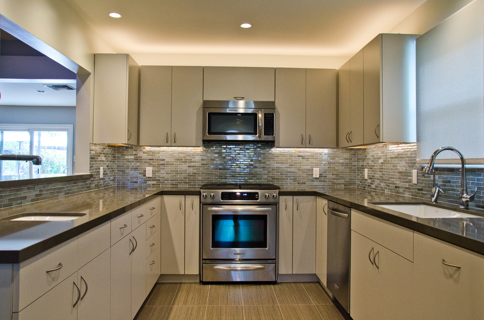 Medium sized contemporary u-shaped kitchen/diner in Los Angeles with a submerged sink, flat-panel cabinets, grey cabinets, engineered stone countertops, stainless steel appliances, porcelain flooring and no island.