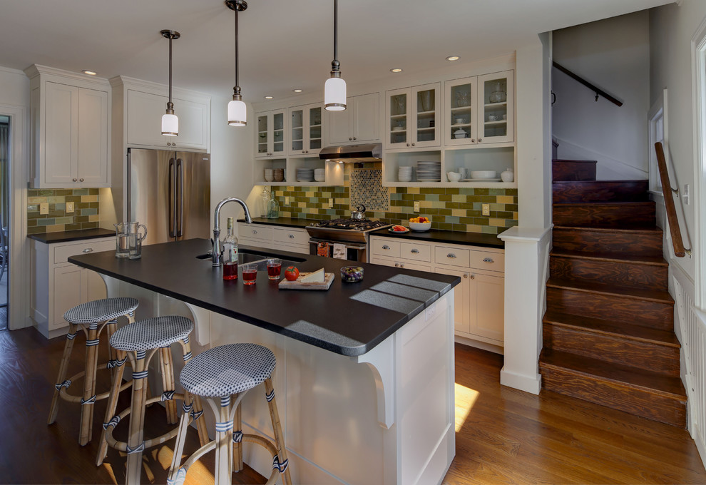 Mid-sized elegant l-shaped light wood floor eat-in kitchen photo in Portland Maine with shaker cabinets, white cabinets, stainless steel appliances, an island, a double-bowl sink, soapstone countertops, multicolored backsplash and subway tile backsplash