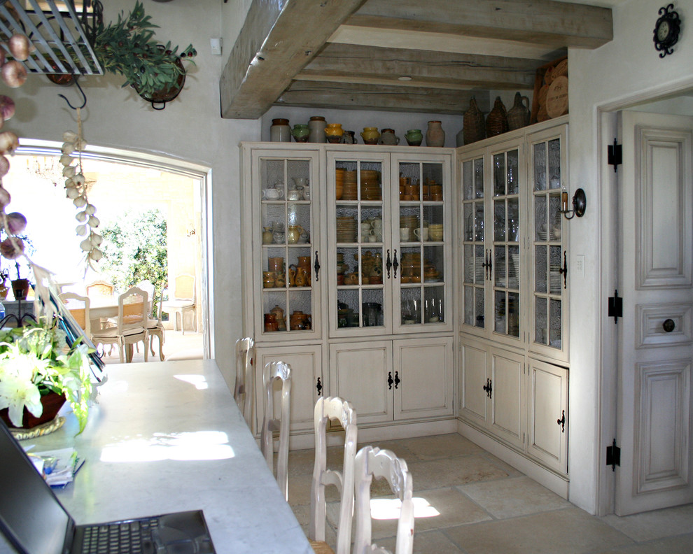 Exempel på ett stort medelhavsstil vit vitt kök, med en rustik diskho, skåp i slitet trä, marmorbänkskiva, rostfria vitvaror, kalkstensgolv, luckor med infälld panel, vitt stänkskydd, en köksö, stänkskydd i marmor och beiget golv
