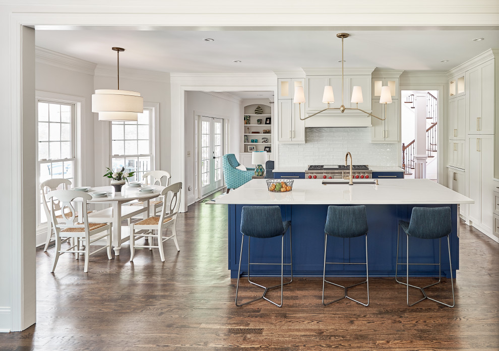 Inspiration for a large traditional l-shaped kitchen/diner in Charlotte with a submerged sink, recessed-panel cabinets, engineered stone countertops, stainless steel appliances, medium hardwood flooring, an island, brown floors and yellow worktops.