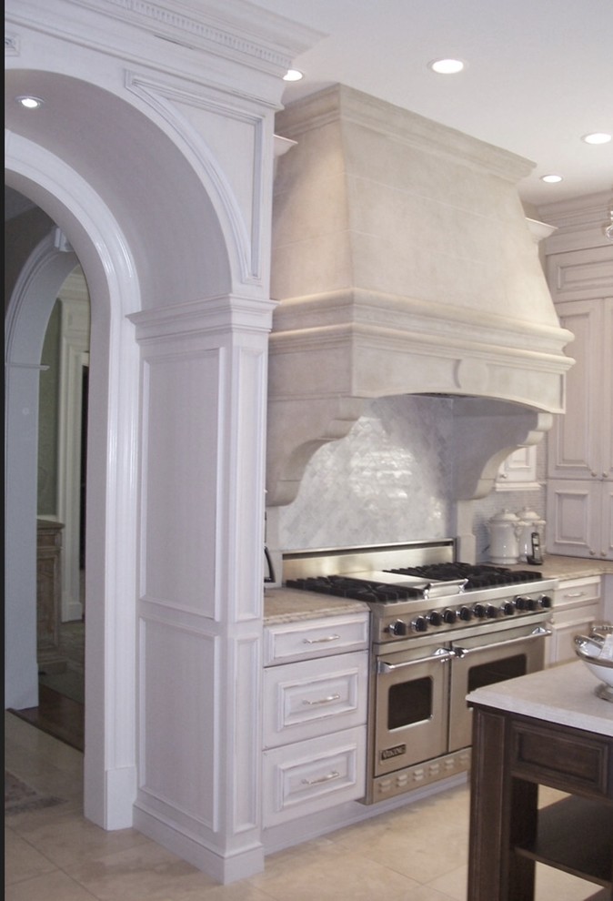 Inspiration for a mid-sized timeless limestone floor enclosed kitchen remodel in Raleigh with recessed-panel cabinets, white cabinets, marble countertops, gray backsplash, marble backsplash, stainless steel appliances and an island