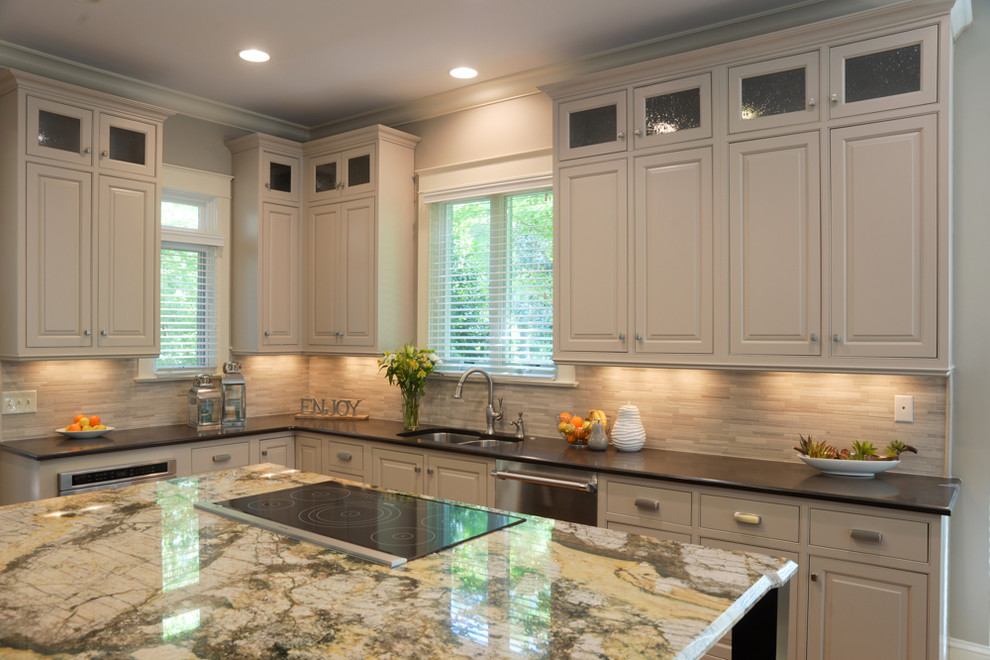 Inspiration for a mid-sized transitional l-shaped medium tone wood floor kitchen remodel in Charlotte with an undermount sink, glass-front cabinets, granite countertops, multicolored backsplash, ceramic backsplash, stainless steel appliances and an island