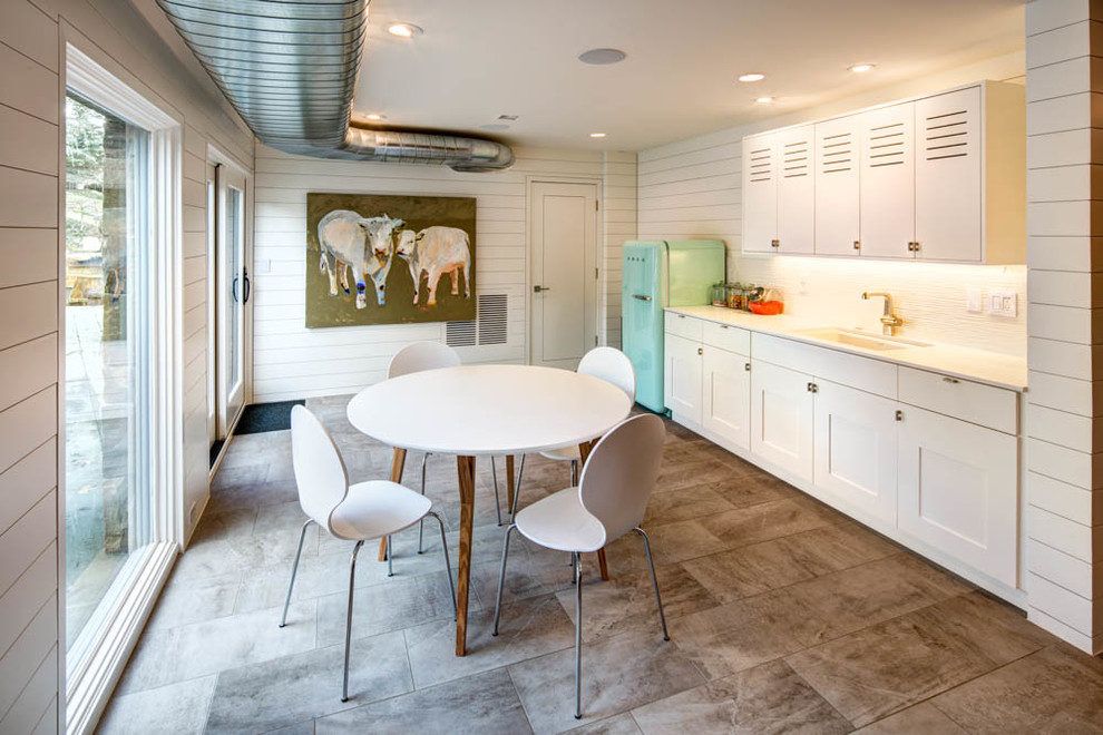 Einzeilige Moderne Wohnküche ohne Insel mit Schrankfronten im Shaker-Stil, weißen Schränken, Küchenrückwand in Weiß, bunten Elektrogeräten und grauem Boden in Salt Lake City