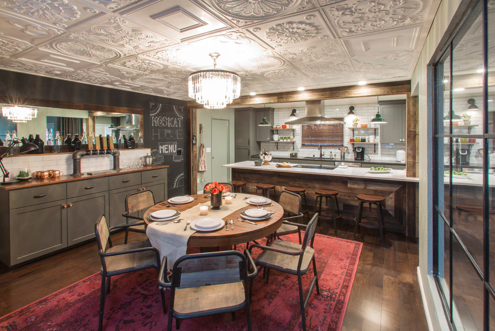 Foto på ett stort funkis linjärt kök och matrum, med en undermonterad diskho, skåp i shakerstil, grå skåp, vitt stänkskydd, stänkskydd i keramik, rostfria vitvaror, mellanmörkt trägolv och en köksö