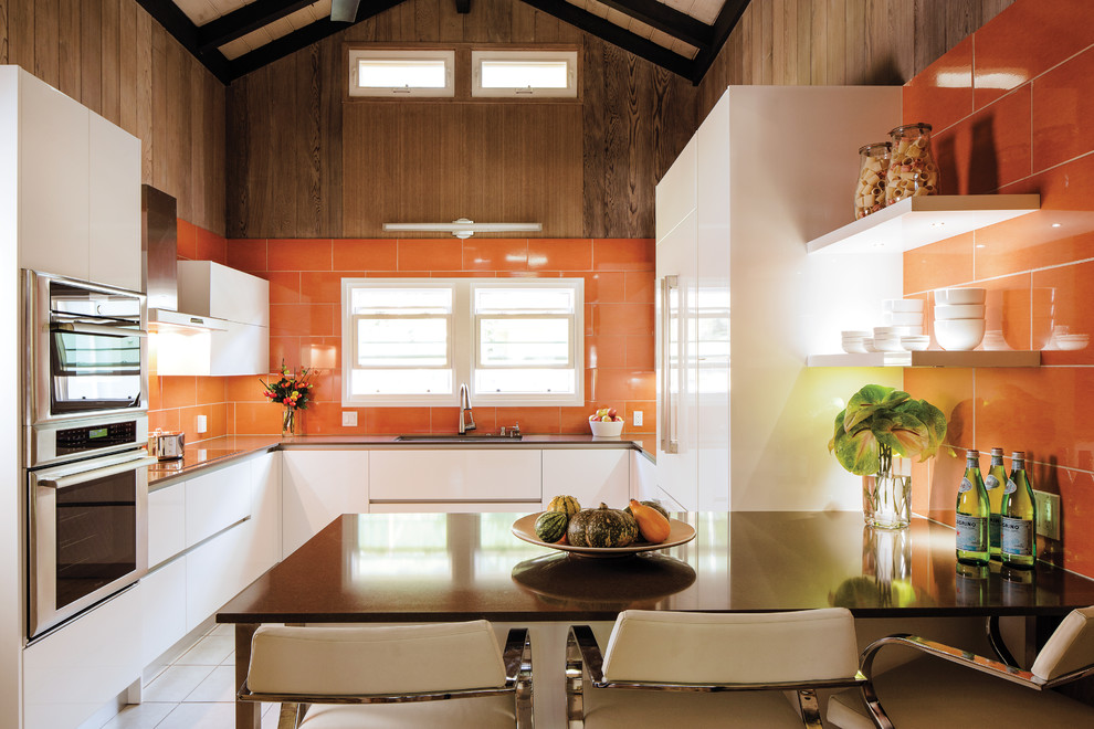 Свежая идея для дизайна: отдельная, п-образная кухня среднего размера в современном стиле с плоскими фасадами, белыми фасадами, столешницей из кварцевого агломерата, оранжевым фартуком, фартуком из керамической плитки, полуостровом и одинарной мойкой - отличное фото интерьера