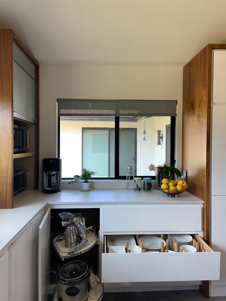 Mid-sized 1950s l-shaped porcelain tile, gray floor and vaulted ceiling open concept kitchen photo in San Diego with an undermount sink, flat-panel cabinets, white cabinets, quartz countertops, white backsplash, quartz backsplash, stainless steel appliances, an island and white countertops