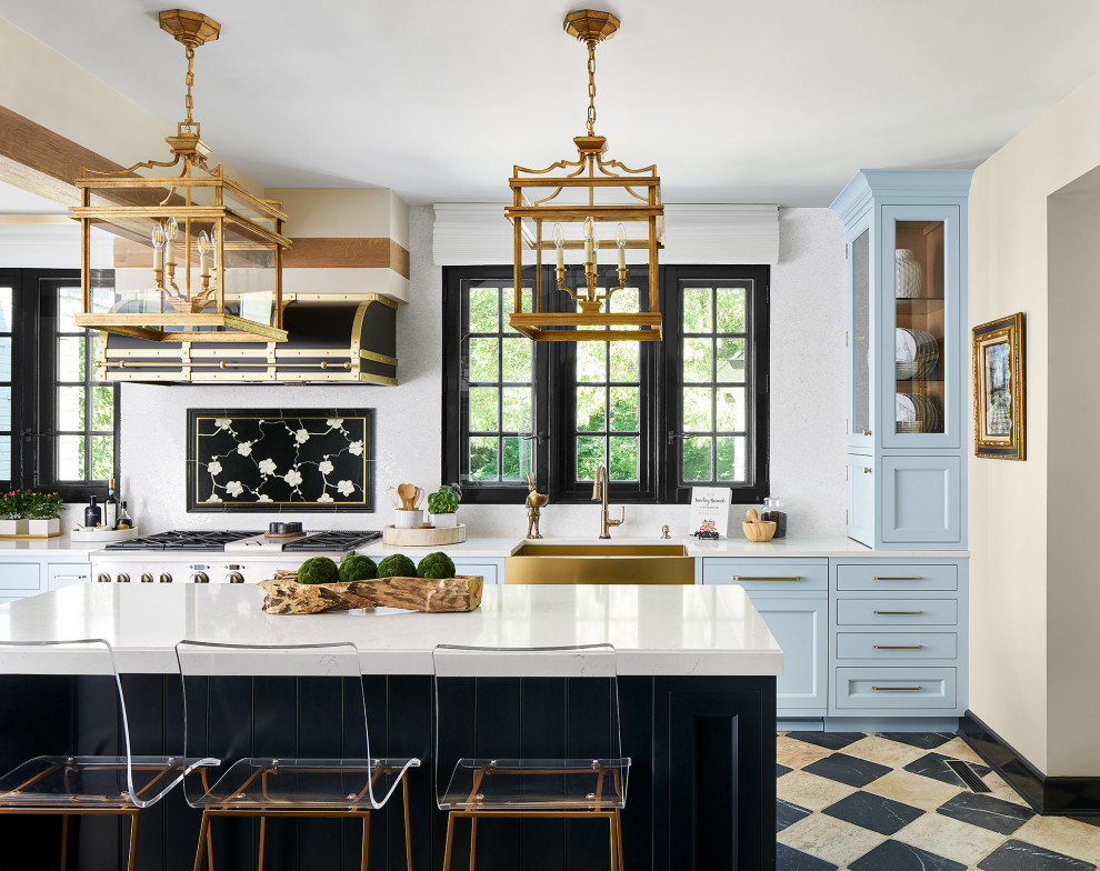 Aménagement d'une grande cuisine américaine classique avec un placard avec porte à panneau encastré, des portes de placard bleues, un plan de travail en quartz modifié, îlot et un plan de travail blanc.