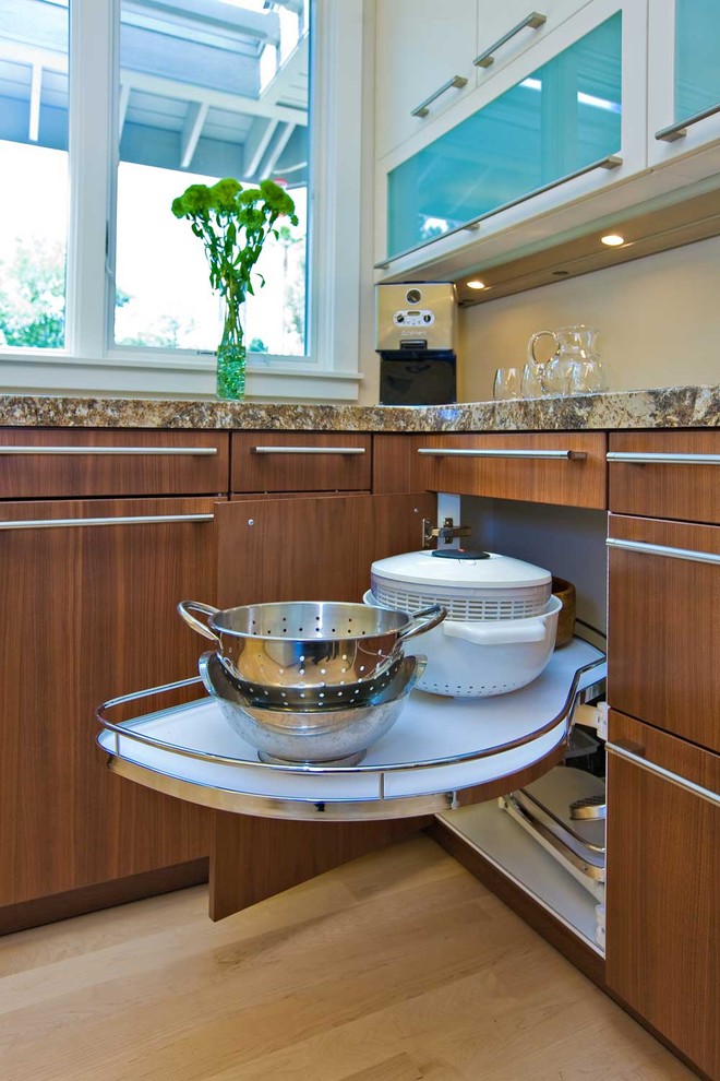 Example of a large trendy u-shaped beige floor and light wood floor open concept kitchen design in San Francisco with flat-panel cabinets, granite countertops, stainless steel appliances, an island, an undermount sink, white cabinets, white backsplash and multicolored countertops