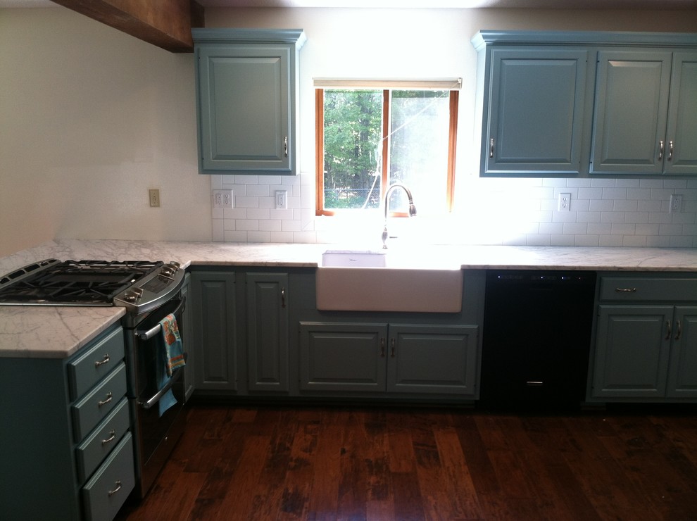 Foto på ett lantligt kök och matrum, med en rustik diskho, luckor med upphöjd panel, marmorbänkskiva, vitt stänkskydd, stänkskydd i tunnelbanekakel, mellanmörkt trägolv och blå skåp