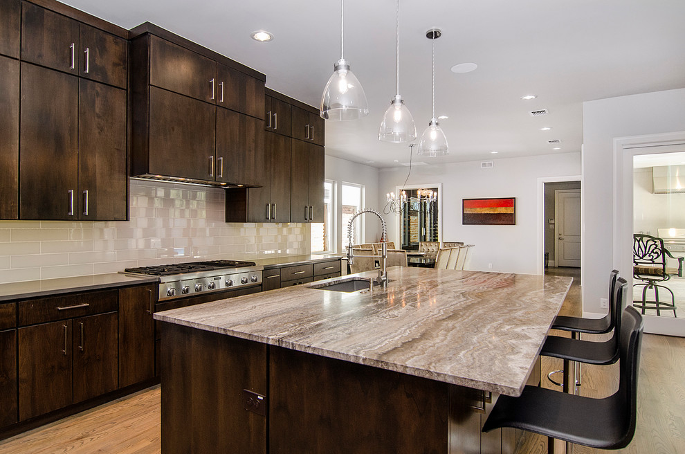 Inspiration for a large transitional l-shaped light wood floor open concept kitchen remodel in Dallas with an undermount sink, flat-panel cabinets, dark wood cabinets, quartzite countertops, beige backsplash, glass tile backsplash, stainless steel appliances and an island