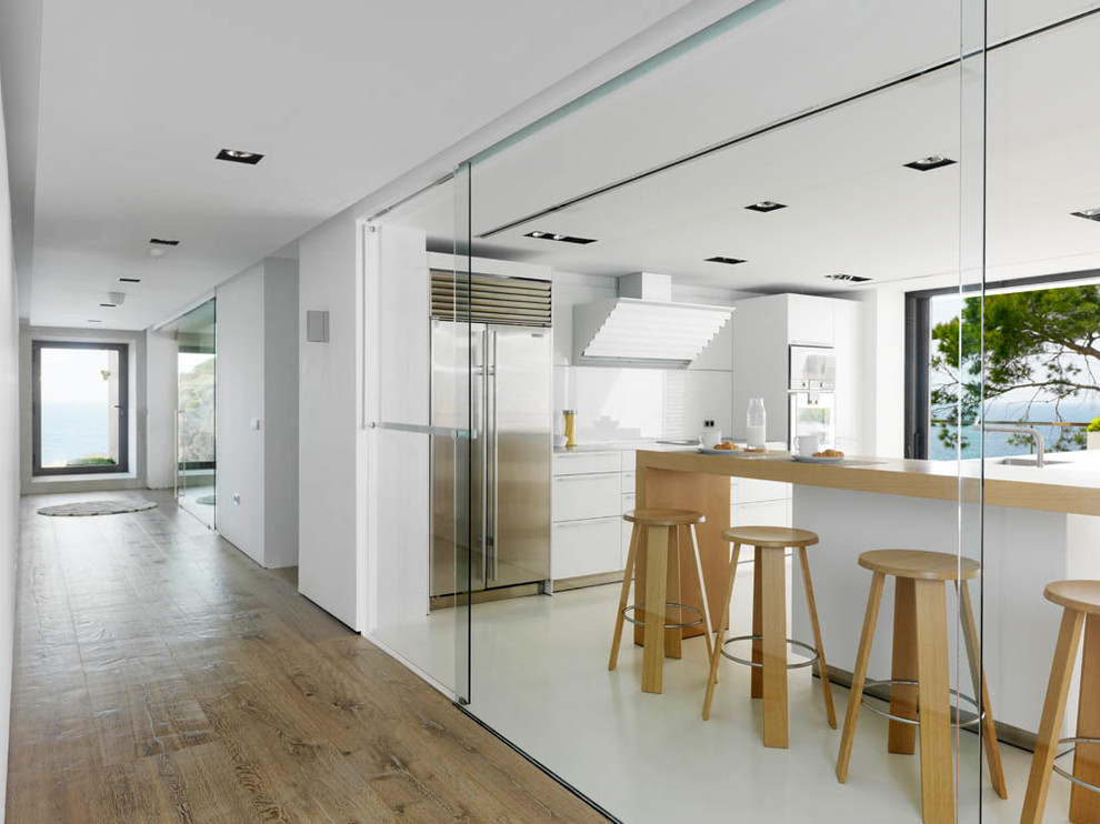 Источник вдохновения для домашнего уюта: отдельная кухня в современном стиле с плоскими фасадами, белыми фасадами, белым фартуком и техникой из нержавеющей стали