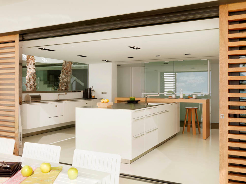 Diseño de cocina actual con armarios con paneles lisos y puertas de armario blancas