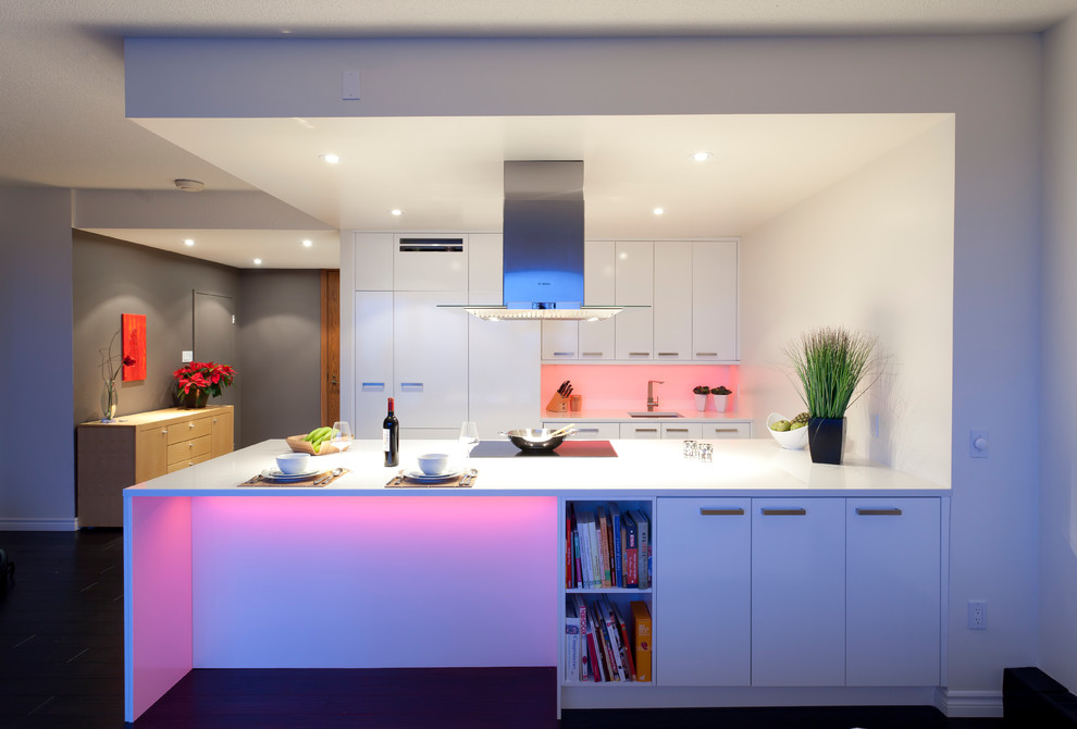 Photo of a medium sized modern galley kitchen/diner in Other with flat-panel cabinets, white cabinets, integrated appliances, a submerged sink, white splashback and a breakfast bar.