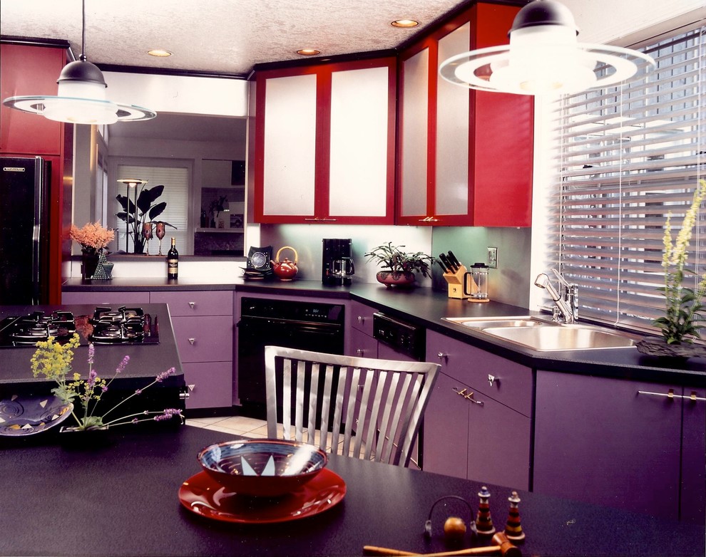 На фото: угловая кухня в современном стиле с обеденным столом, двойной мойкой, плоскими фасадами, красными фасадами, столешницей из ламината, фартуком цвета металлик и черной техникой с