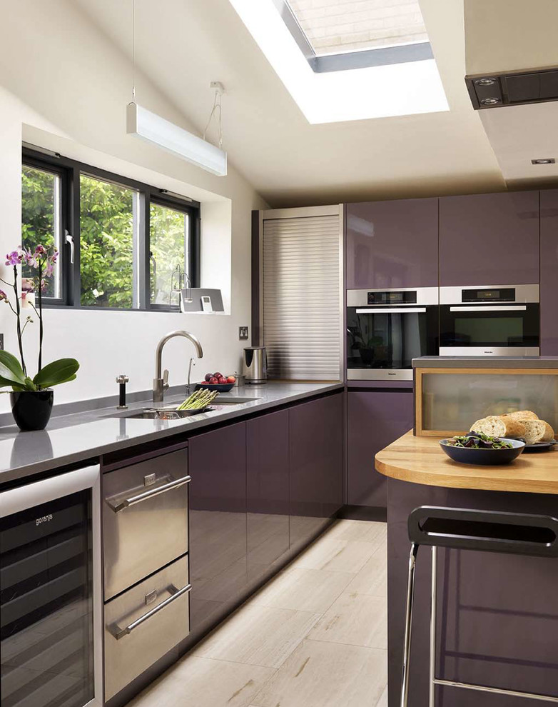 Modelo de cocina contemporánea abierta con armarios con paneles lisos, puertas de armario violetas, encimera de acrílico, electrodomésticos de acero inoxidable y península