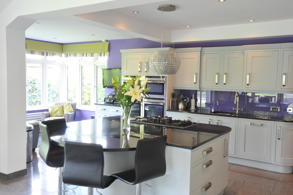 This is an example of a large contemporary kitchen/diner in Buckinghamshire with a submerged sink, shaker cabinets, grey cabinets, granite worktops, glass sheet splashback, stainless steel appliances, porcelain flooring and an island.