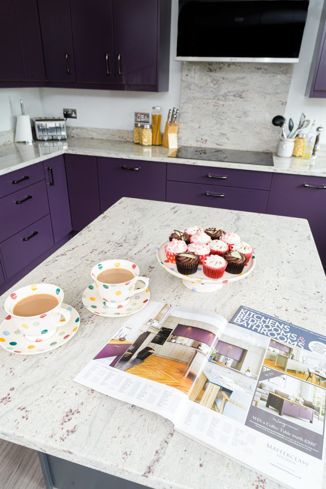 Foto de cocina comedor ecléctica grande con armarios con paneles lisos, puertas de armario violetas, encimera de granito y una isla