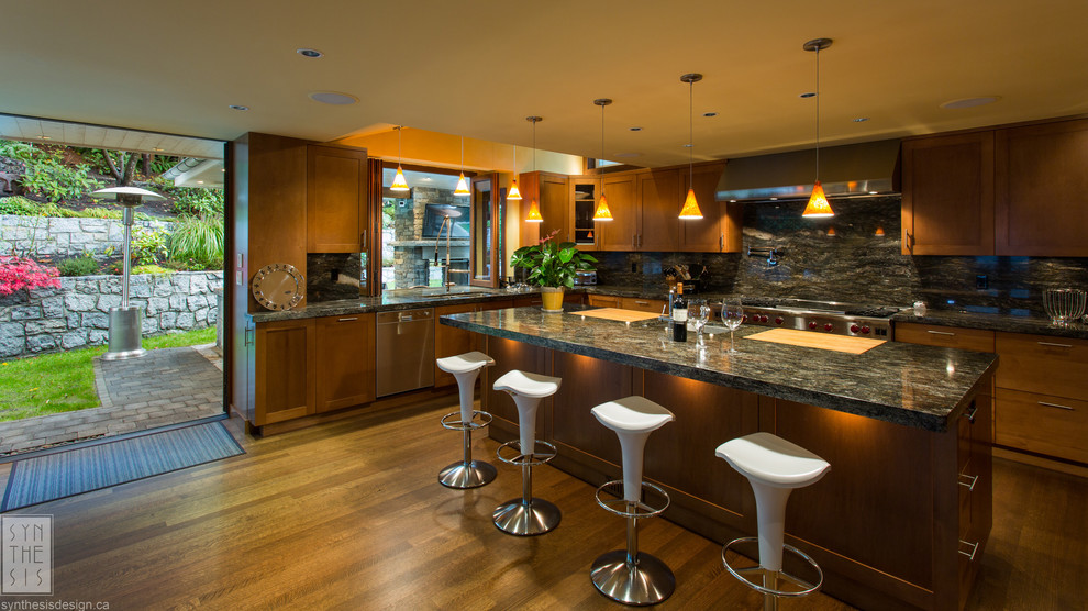 Modern inredning av ett stort flerfärgad flerfärgat kök, med en undermonterad diskho, mörkt trägolv, brunt golv, skåp i shakerstil, skåp i mellenmörkt trä, granitbänkskiva, flerfärgad stänkskydd, stänkskydd i sten, rostfria vitvaror och en köksö