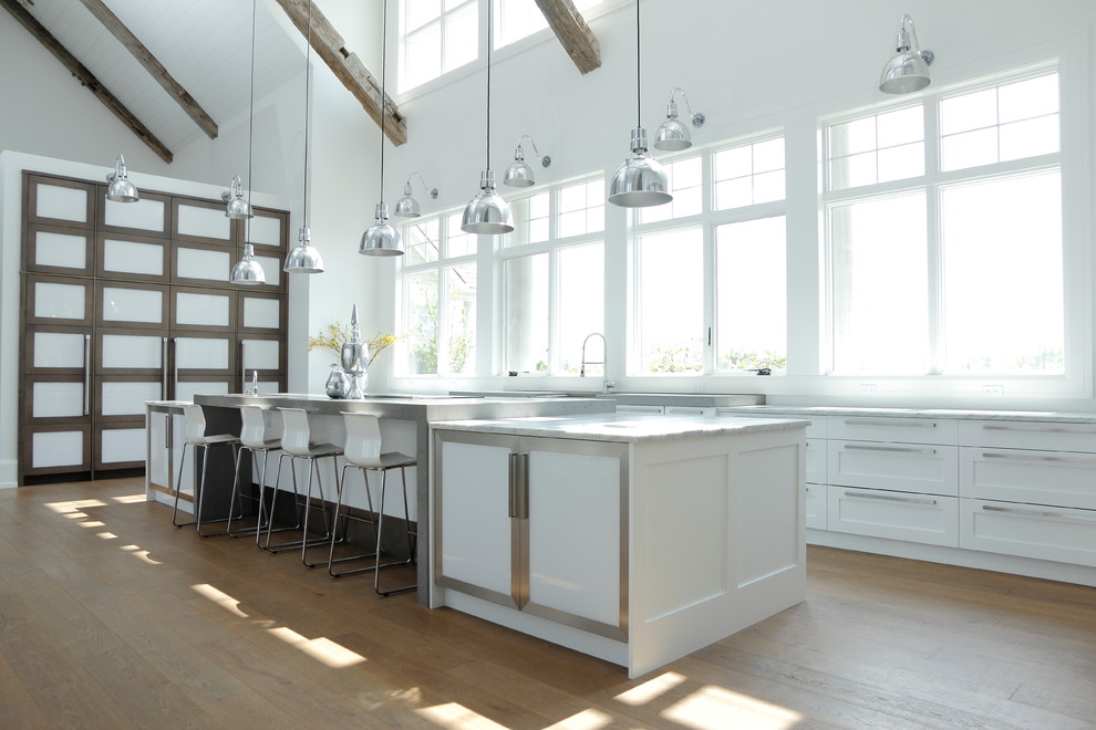 Geräumige Landhaus Küche mit Schrankfronten im Shaker-Stil, weißen Schränken, Marmor-Arbeitsplatte, Elektrogeräten mit Frontblende, braunem Holzboden und Kücheninsel in Toronto