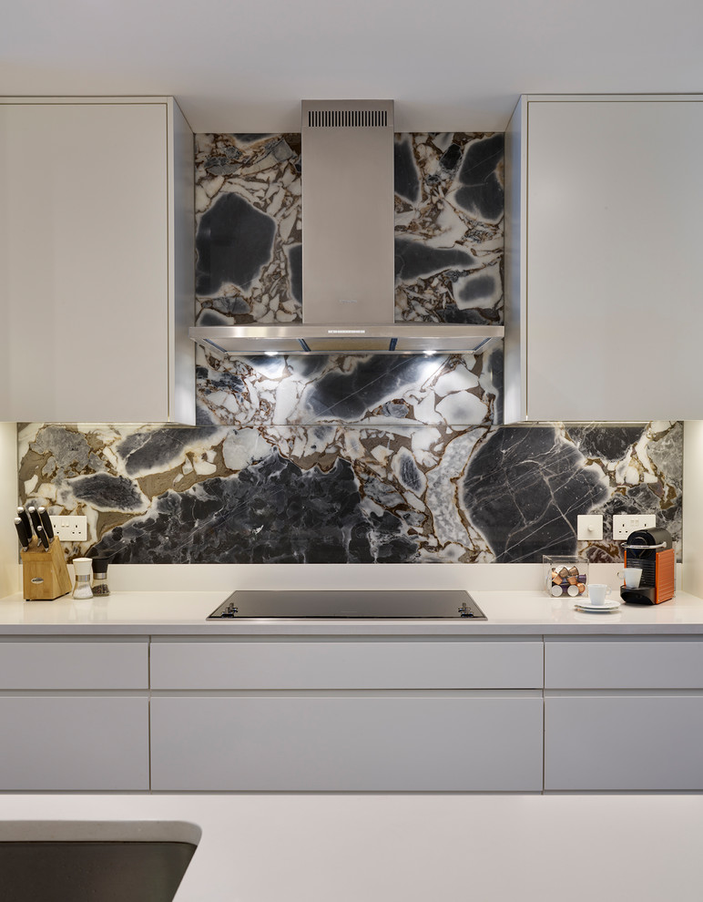 Moderne Küche mit Rückwand aus Marmor und Kücheninsel in London