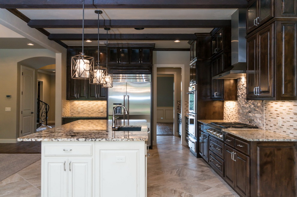 Example of a huge transitional open concept kitchen design in Oklahoma City with a drop-in sink, dark wood cabinets, granite countertops, black backsplash, glass tile backsplash, stainless steel appliances and an island