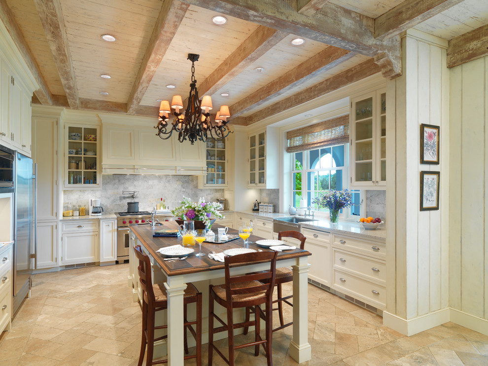 Exempel på ett klassiskt kök, med en rustik diskho, luckor med glaspanel, vita skåp, grått stänkskydd, rostfria vitvaror och en köksö