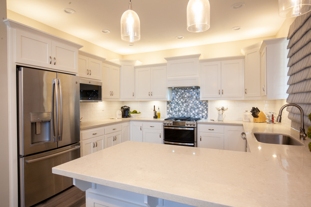 Immagine di una cucina abitabile moderna con lavello sottopiano, ante con riquadro incassato, ante bianche, top in quarzite, paraspruzzi grigio, paraspruzzi con piastrelle a mosaico, elettrodomestici in acciaio inossidabile, pavimento marrone e top beige