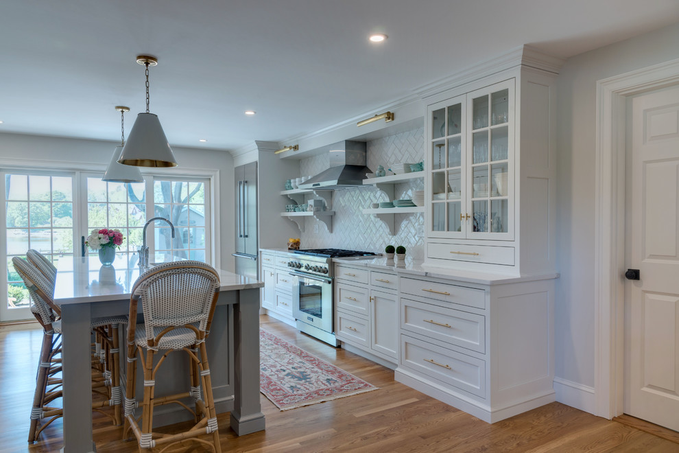 Klassische Küche mit weißen Schränken, Quarzit-Arbeitsplatte, Küchengeräten aus Edelstahl und Kücheninsel in Boston