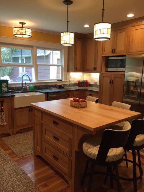 Foto på ett avskilt, mellanstort amerikanskt l-kök, med en rustik diskho, skåp i shakerstil, bänkskiva i täljsten, grått stänkskydd, stänkskydd i stenkakel, rostfria vitvaror, mellanmörkt trägolv, en köksö och skåp i mellenmörkt trä