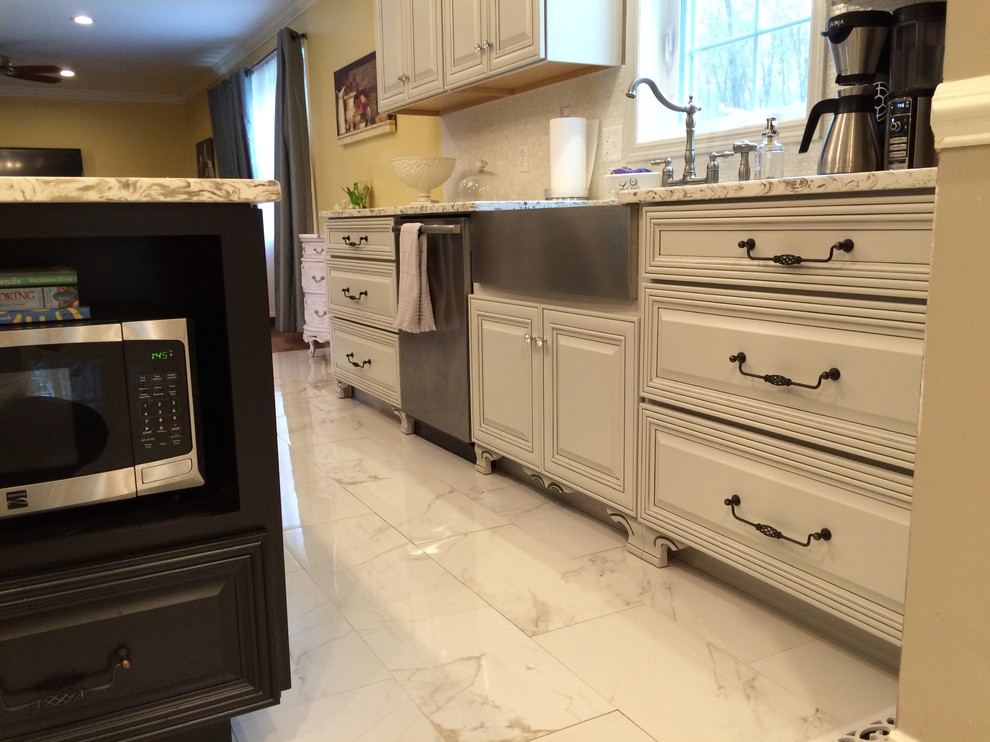 Example of a large classic u-shaped marble floor eat-in kitchen design in New York with a farmhouse sink, raised-panel cabinets, white cabinets, granite countertops, stainless steel appliances and an island