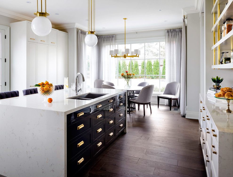 Design ideas for a traditional kitchen in Grand Rapids with a submerged sink, shaker cabinets, black cabinets, an island and brown floors.