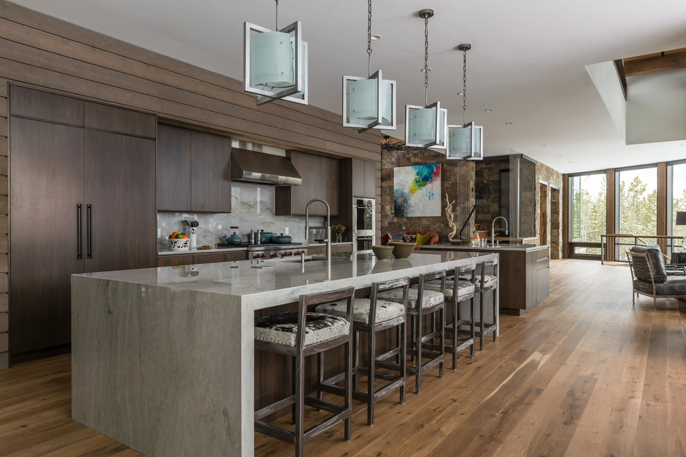 Immagine di una cucina minimal con lavello sottopiano, ante lisce, ante in legno bruno, paraspruzzi grigio, pavimento in legno massello medio e elettrodomestici da incasso