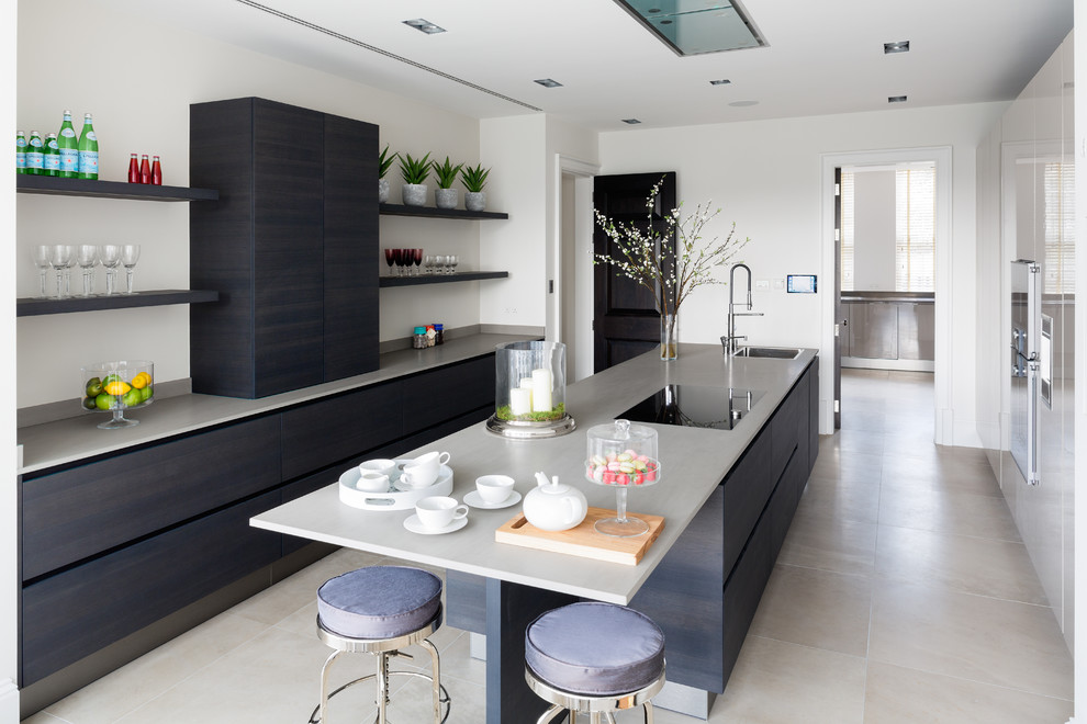 Bild på ett mellanstort funkis grå linjärt grått kök, med en undermonterad diskho, släta luckor, blå skåp, bänkskiva i kvartsit, integrerade vitvaror, en köksö och beiget golv