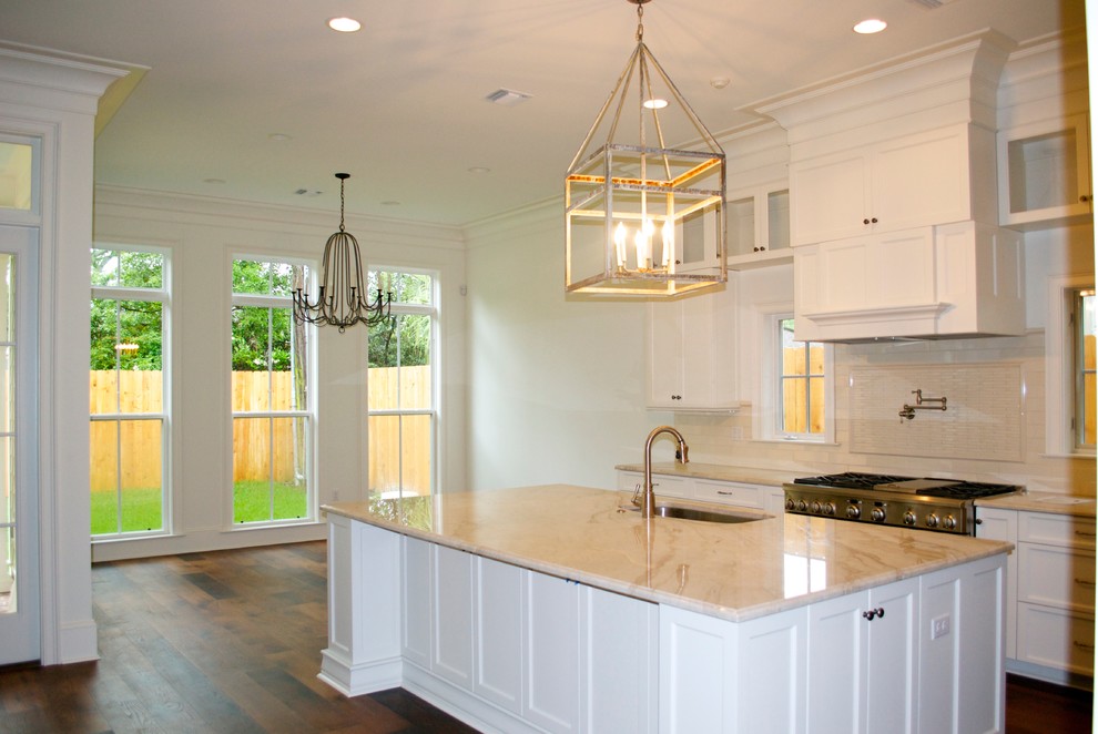 Inspiration for a medium sized traditional u-shaped kitchen in New Orleans with a submerged sink, shaker cabinets, white cabinets, quartz worktops, beige splashback, stainless steel appliances, dark hardwood flooring and an island.