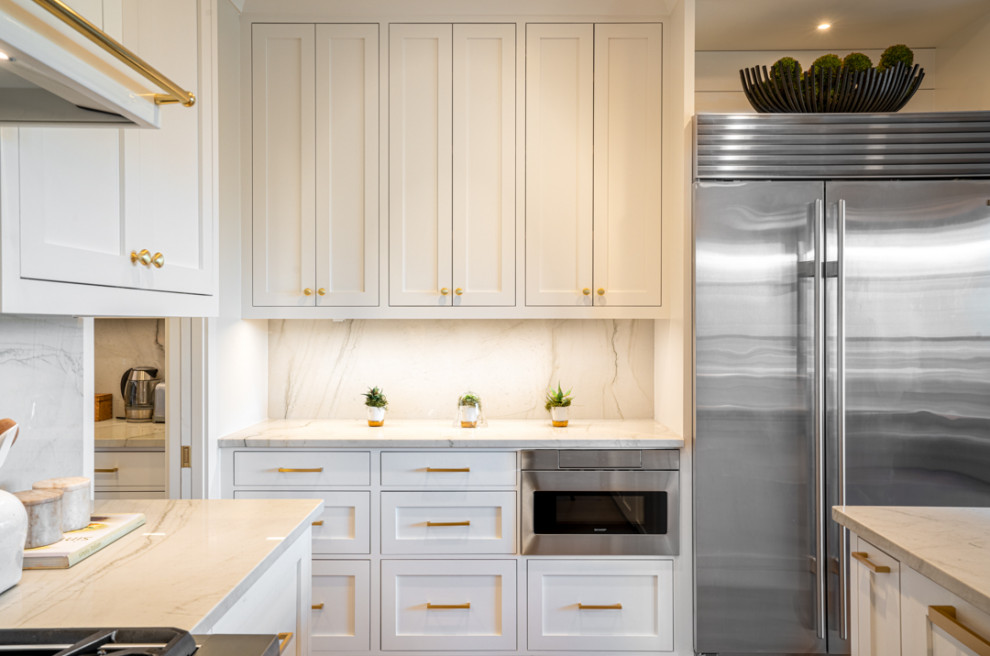 Design ideas for a large modern kitchen in Nashville with white cabinets, quartz worktops, stone slab splashback, stainless steel appliances, light hardwood flooring and an island.