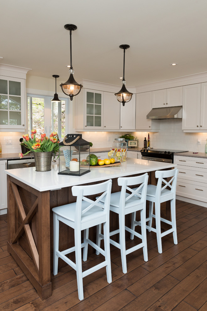 Example of a beach style dark wood floor kitchen design in Ottawa with shaker cabinets, white cabinets, white backsplash, subway tile backsplash and an island