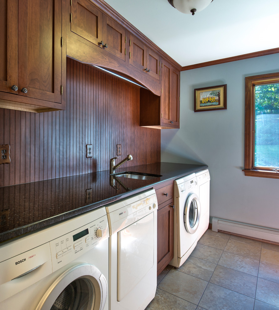 Example of a small eclectic single-wall porcelain tile dedicated laundry room design in Burlington with an undermount sink, recessed-panel cabinets, medium tone wood cabinets, granite countertops, blue walls and a side-by-side washer/dryer
