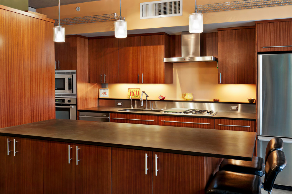 Zweizeilige Moderne Wohnküche mit Unterbauwaschbecken, flächenbündigen Schrankfronten, dunklen Holzschränken, Granit-Arbeitsplatte, Küchenrückwand in Metallic und Küchengeräten aus Edelstahl in Seattle