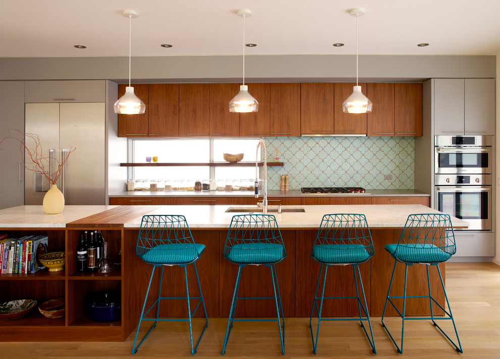 Foto di una cucina minimal di medie dimensioni con lavello sottopiano, ante lisce, ante in legno bruno, top in marmo, elettrodomestici in acciaio inossidabile, parquet chiaro e paraspruzzi blu