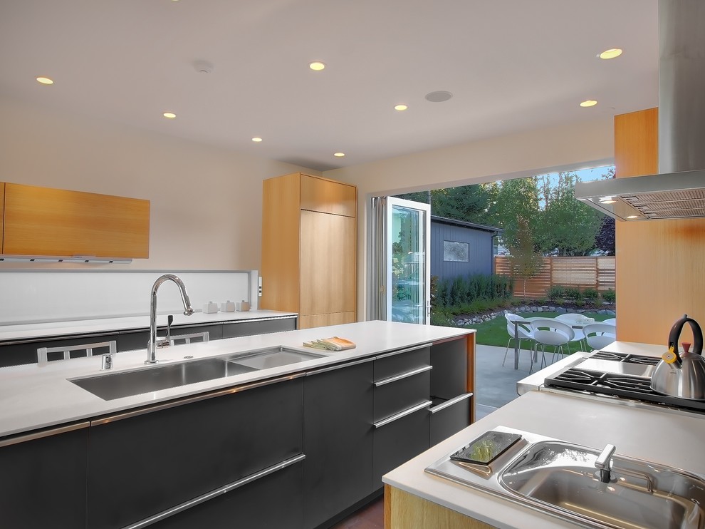 This is an example of a modern galley kitchen in Seattle with flat-panel cabinets and grey cabinets.