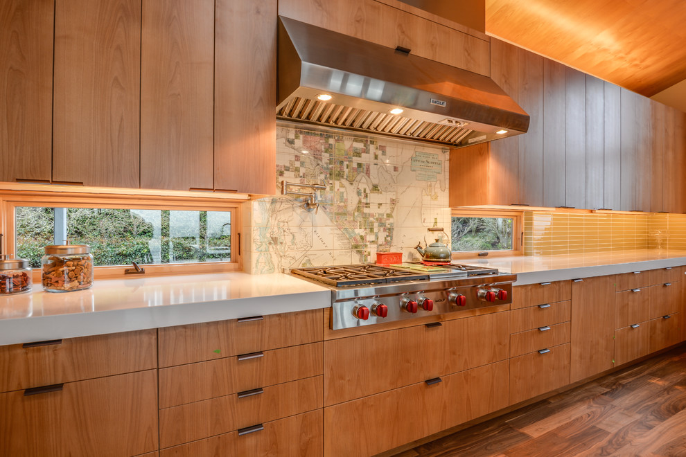 Mid-sized minimalist medium tone wood floor eat-in kitchen photo in Seattle with a double-bowl sink, flat-panel cabinets, medium tone wood cabinets, beige backsplash, ceramic backsplash, stainless steel appliances and an island